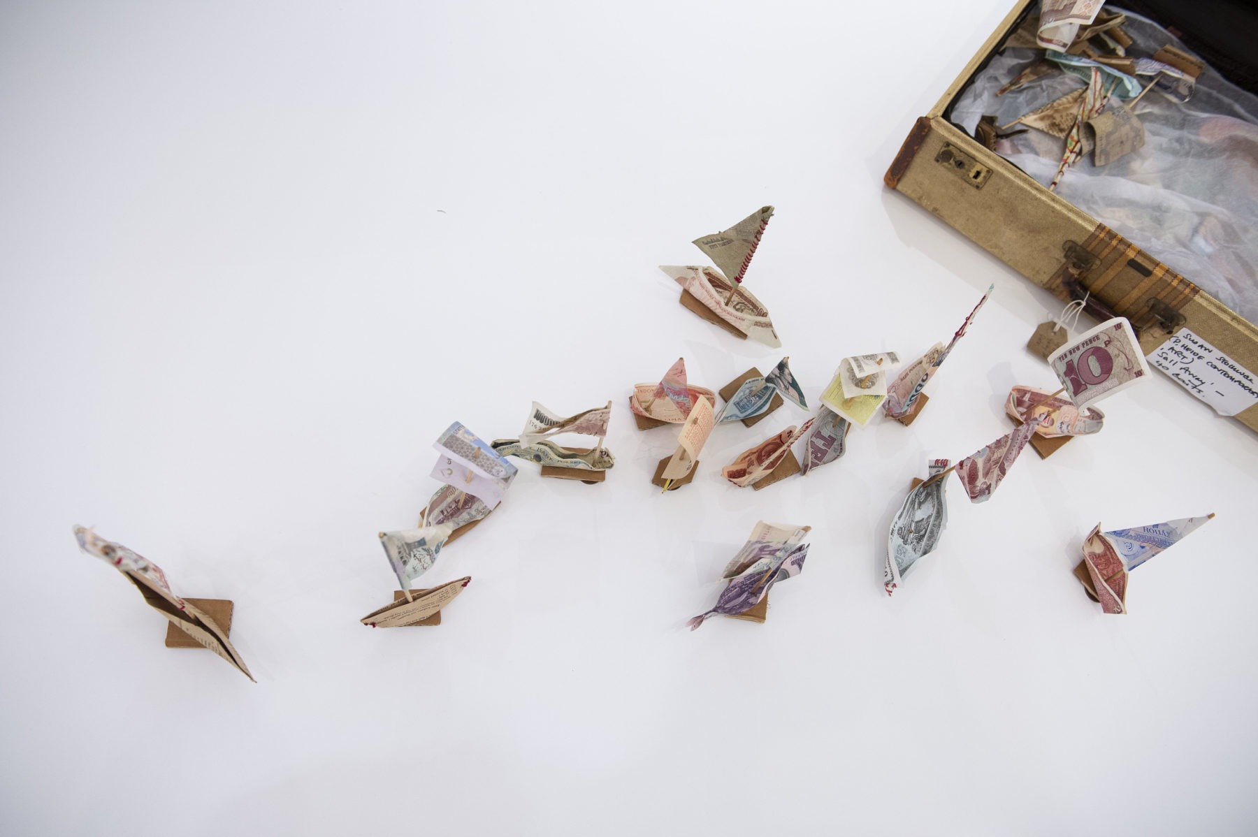 Small boat made of money bills for The Sea is the Limit art exhibition by Susan Stockwell at VCUarts Qatar